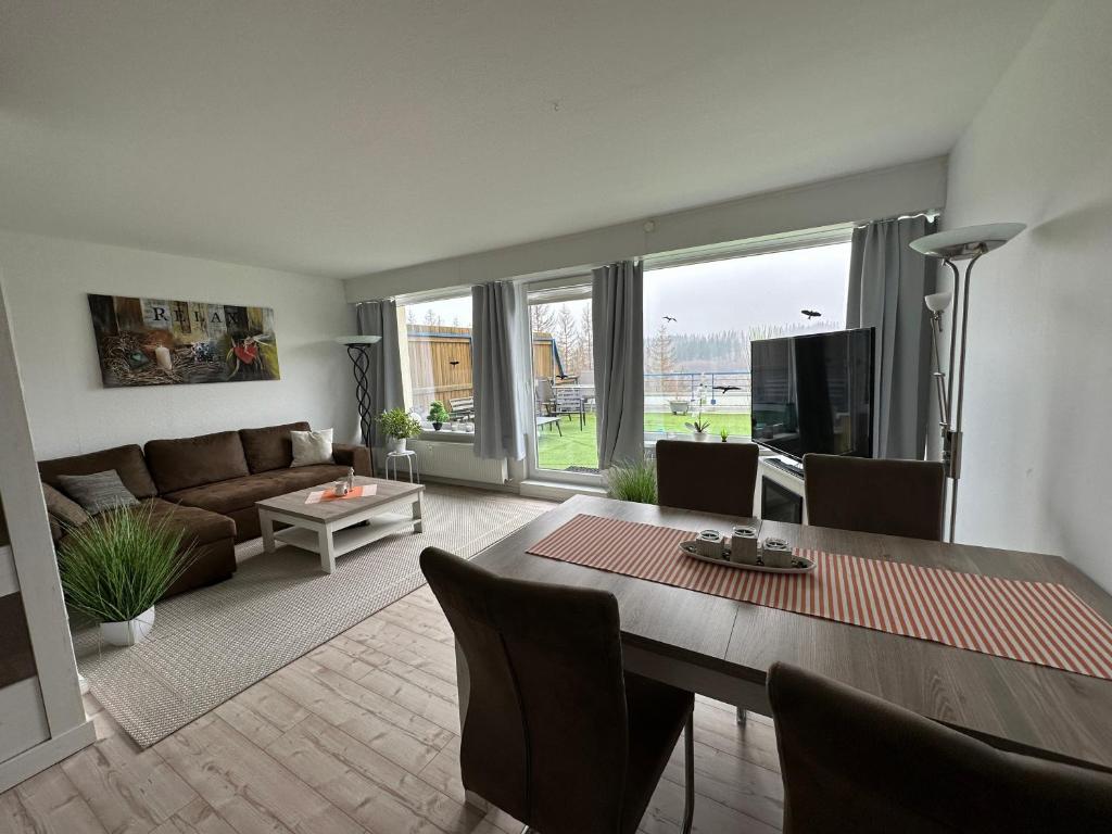 - un salon avec un canapé et une table à manger dans l'établissement Ferienwohnung Harz #4, Pool, Sauna, WLAN, à Braunlage