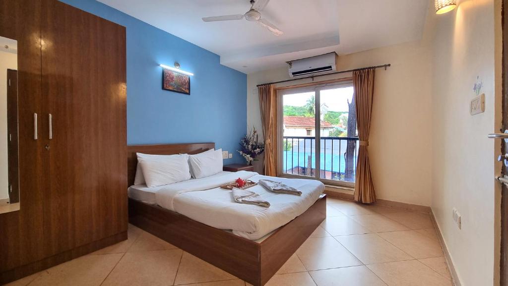 a bedroom with a bed and a window with a balcony at Heritage Exotica Villa 3BHK JAQK Holidays in Arpora