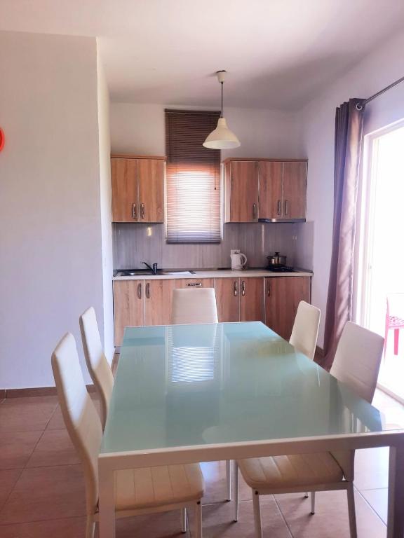 a kitchen with a dining room table and chairs at Apartments Alavana in Velipojë