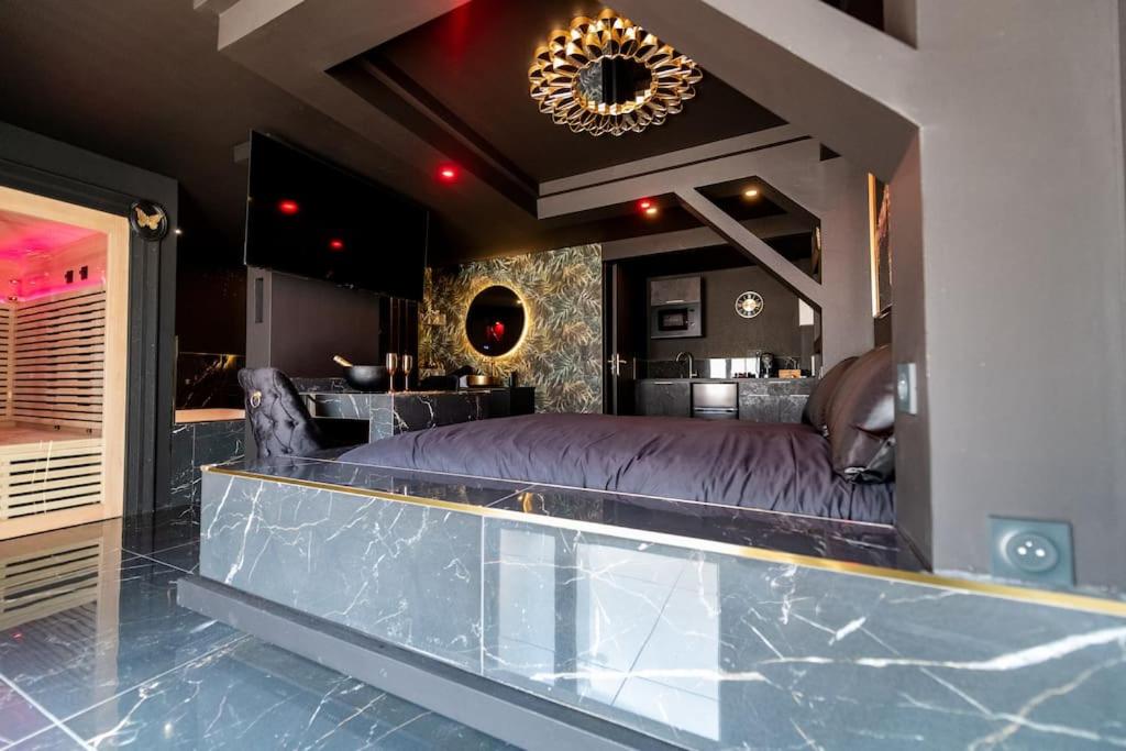 a master bedroom with a large bed and a kitchen at Suite D&S Luxury Room in Firminy
