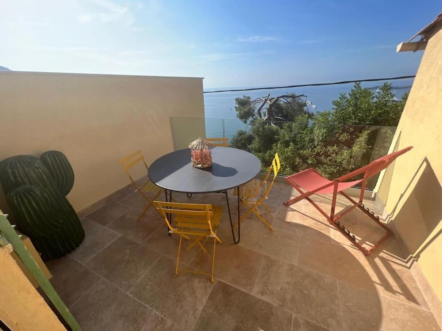 un patio avec une table et des chaises sur un balcon dans l'établissement Entre les citronniers et la mer, à Èze