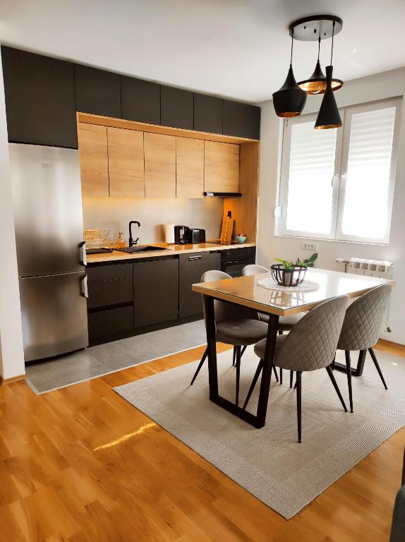 a kitchen with a table and chairs and a refrigerator at Riverside LUX Apartment in Pirot