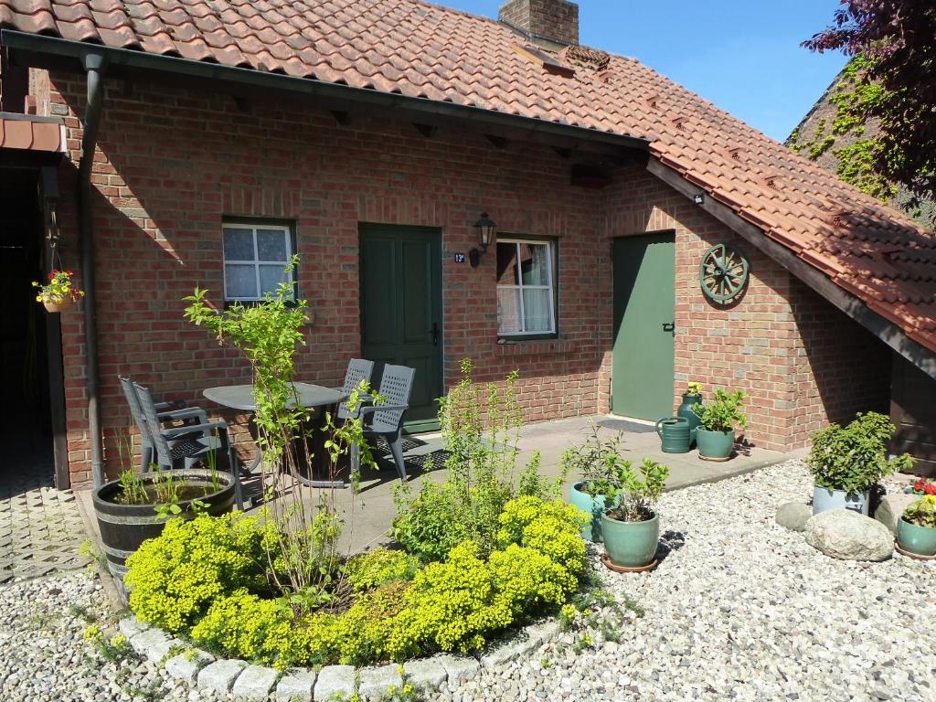 a brick house with a patio with a table and chairs at Haus Peenehagen in Groß Gievitz