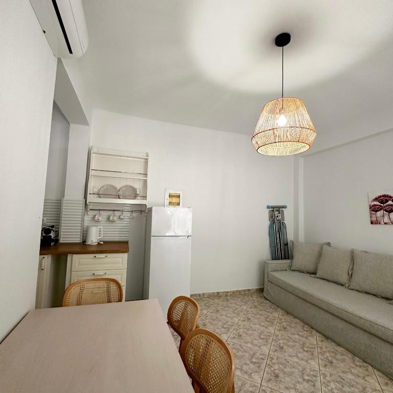 a kitchen and living room with a table and a couch at Petra Mare Apartments in Alyki