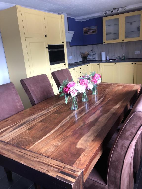 a wooden table with vases of flowers on it at Wittlicher Monteuren - Ferienwohnung in Platten