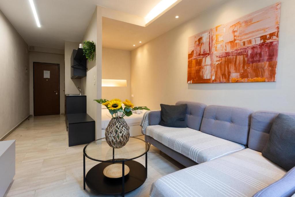 a living room with a couch and a vase of flowers on a table at Tsimiski double suites #8 in Thessaloniki
