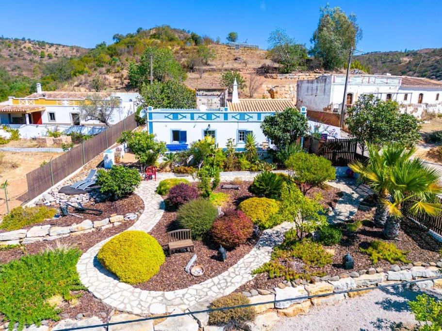 a garden in front of a building with trees and bushes at Casa Catarina Peaceful Farmhouse in Santa Catarina da Fonte do Bispo