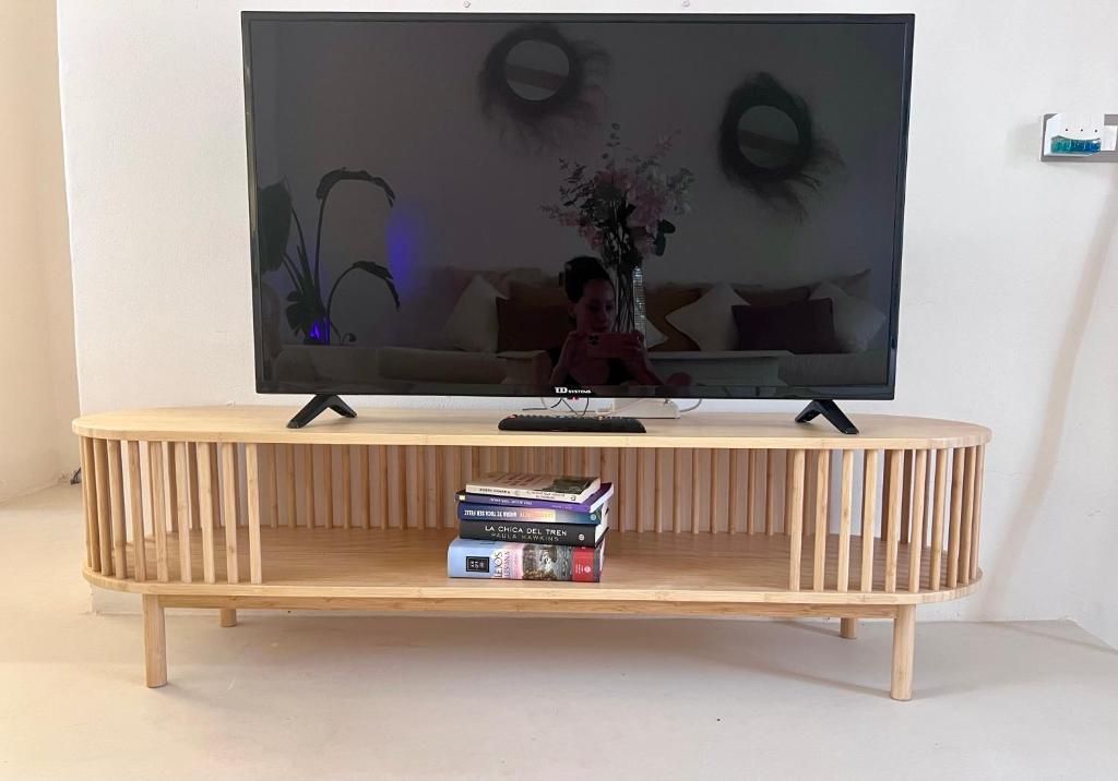 a flat screen tv sitting on top of a wooden stand at Tu Casita Rural in Valdilecha