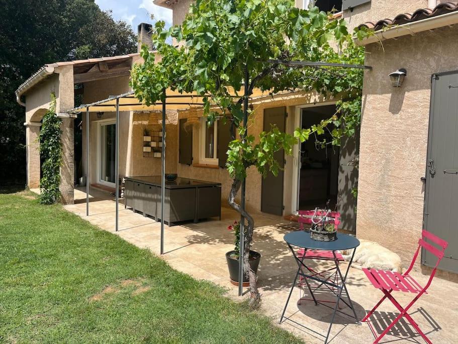 d'une terrasse avec une table, des chaises et un arbre. dans l'établissement Jolie maison provençale avec piscine, à Jouques