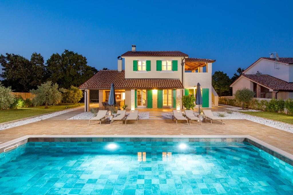 a villa with a swimming pool in front of a house at Villa Jozefina - Istria in Hreljići
