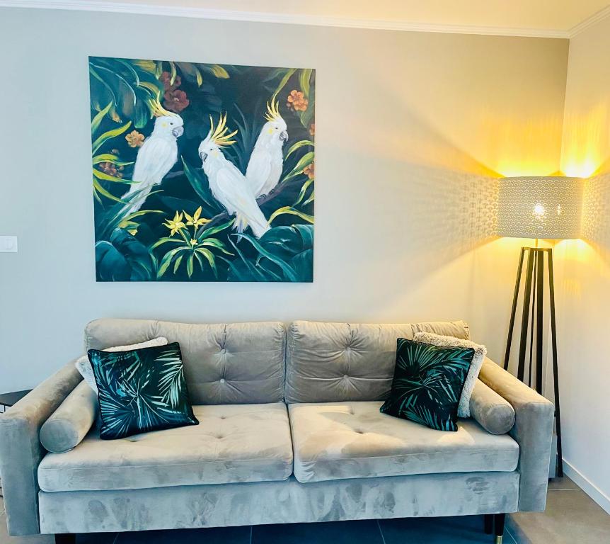 a living room with a couch with a painting on the wall at Appartement de standing proche centre ville et gare in Mulhouse