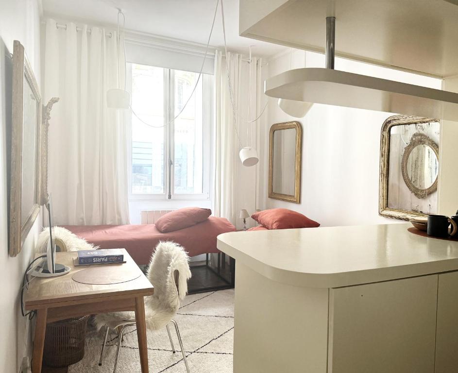 a room with a bed and a kitchen with a table at Studio climatisé pour 1 ou 2 personnes au 109 avenue Mozart Paris 16 in Paris
