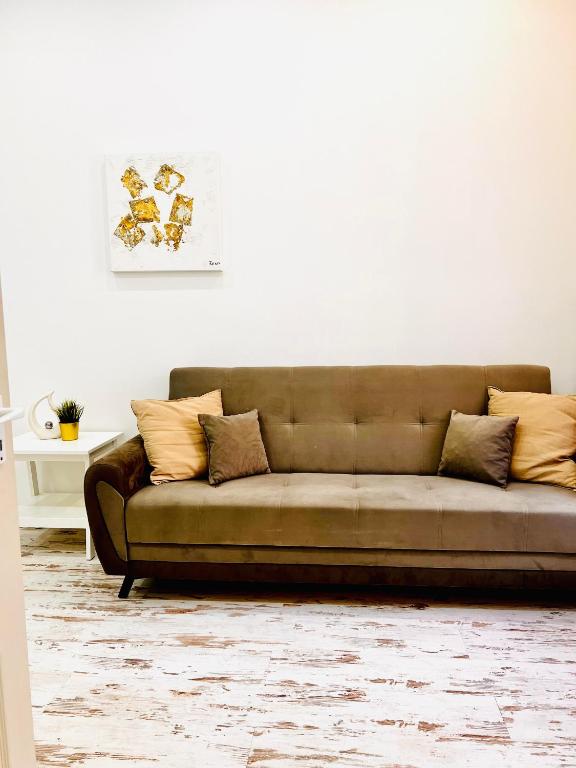 a brown couch in a living room with a white wall at Comfy Luxury Apartment with 2 rooms in the City Centre AA in Budapest