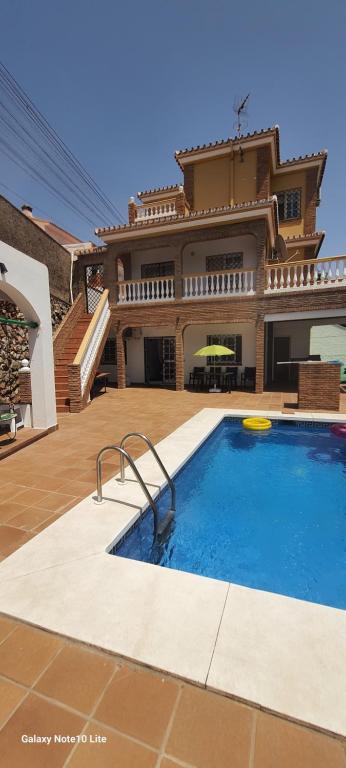 a house with a swimming pool in front of a house at UF holiday Villa in Málaga