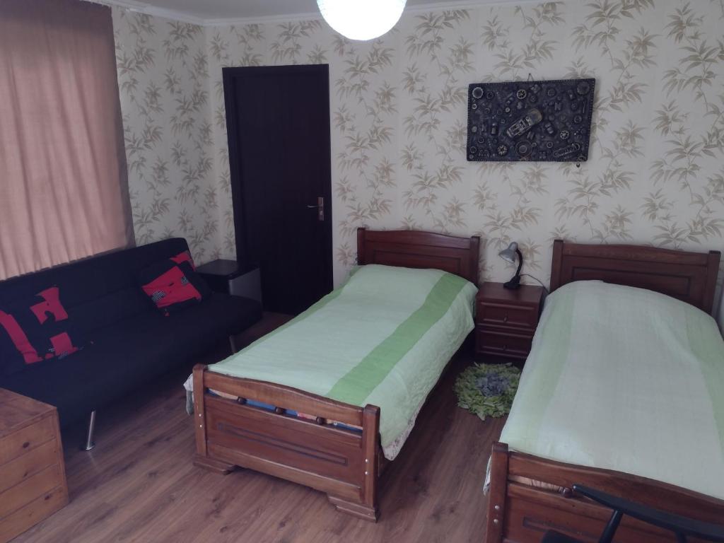 a bedroom with two beds and a couch at Bocro in Mestia