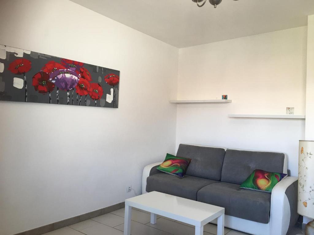 un salon avec un canapé et une table dans l'établissement Appartement 2 étoiles entre les Maures et Méditerranée, à La Londe-les-Maures