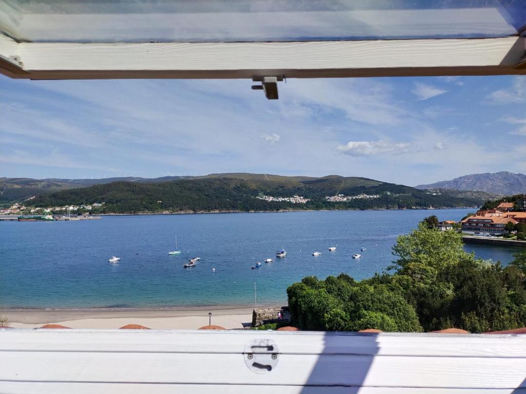 une vue d'une plage avec des bateaux dans l'eau dans l'établissement Ático Agarimos do Mar, à Corcubión