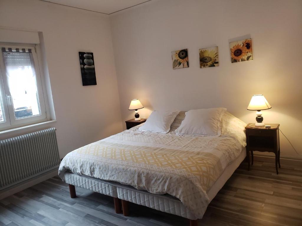 a bedroom with a bed and two lamps on two tables at Gite le figuier de l'ill in Sélestat
