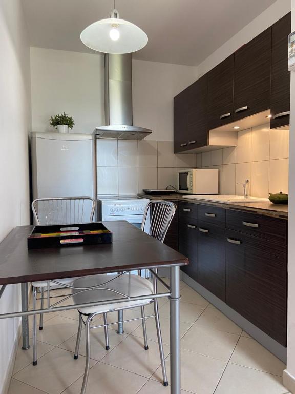 une cuisine avec une table et des chaises dans une cuisine dans l'établissement La belle étape, à Maizières-lès-Metz