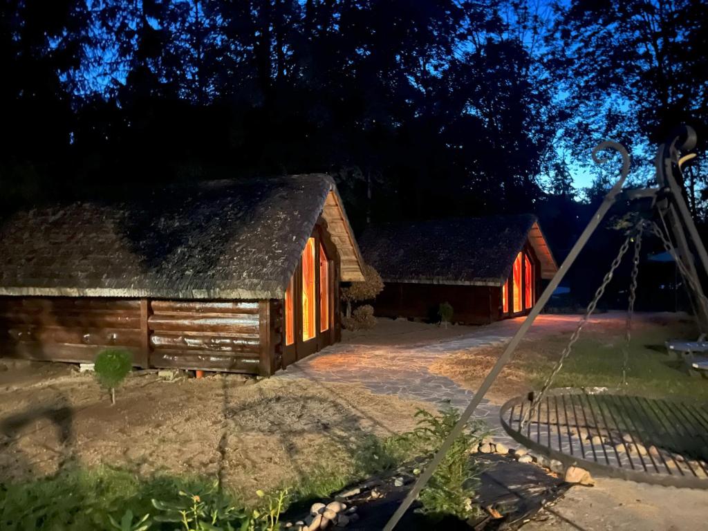 two barns at night with the lights on at Bungalow Bay -2 domki 4 osoby in Łacha
