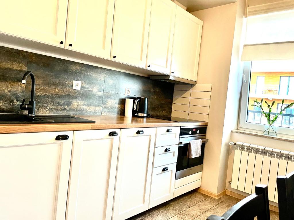 ザトルにあるFrojaの白いキャビネットとシンクのあるキッチン