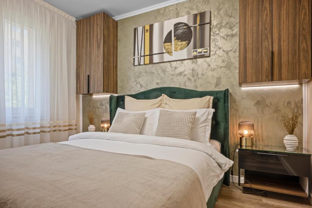 a bedroom with a large bed with a green headboard at Awesome Apartment Bucharest in Bucharest