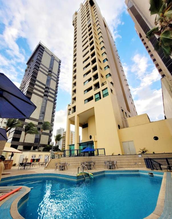 a large swimming pool in front of a building at Flat 10 andar Hotel Caesar Towers acesso direto praia in Recife