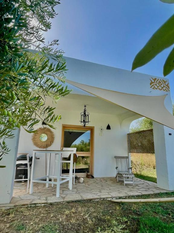 a patio with a white table and chairs at bungalow entre mer et montagne in Arcos de la Frontera