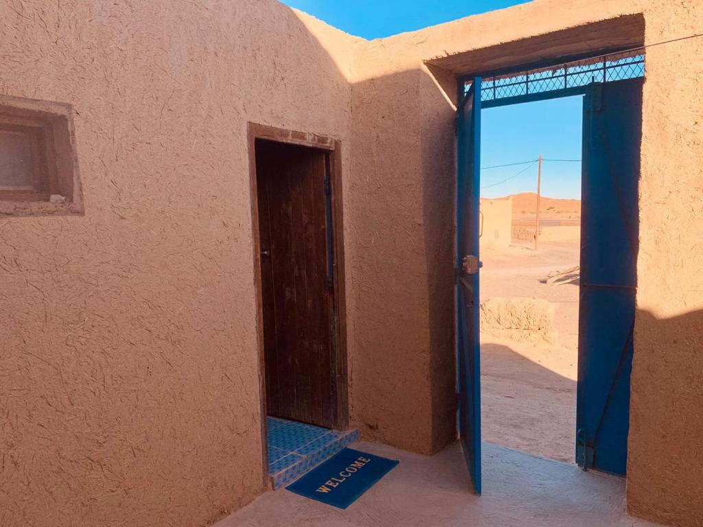 an open door to a building in the desert at maison traditionnelle in Merzouga