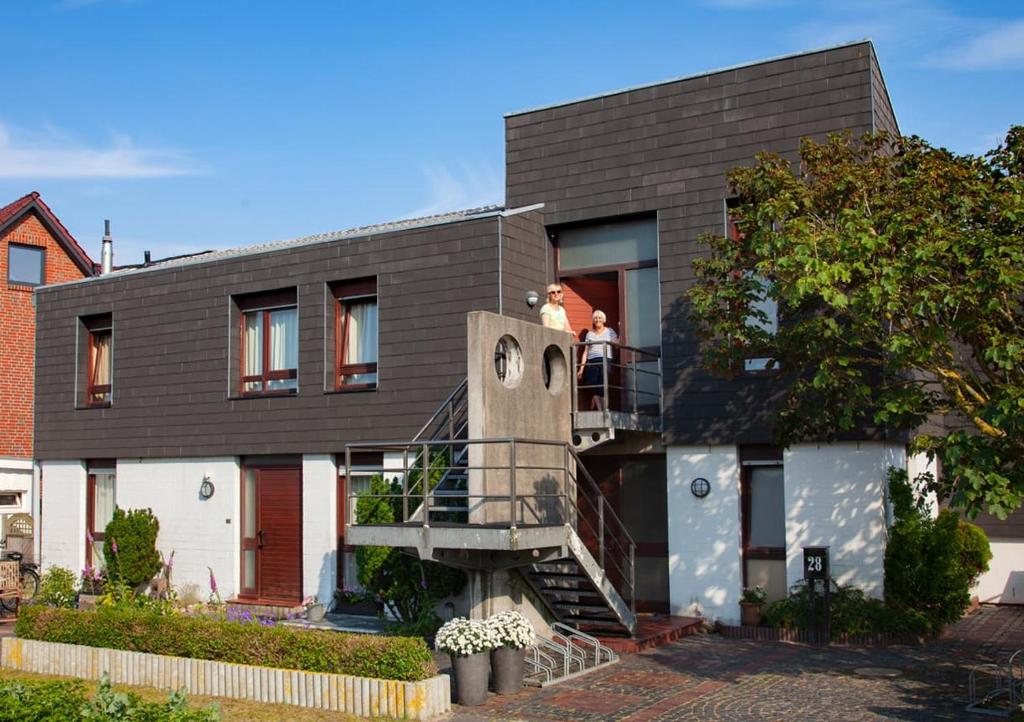 two people standing on the balcony of a house at Ferienhaus Dübbel Norderney in Norderney