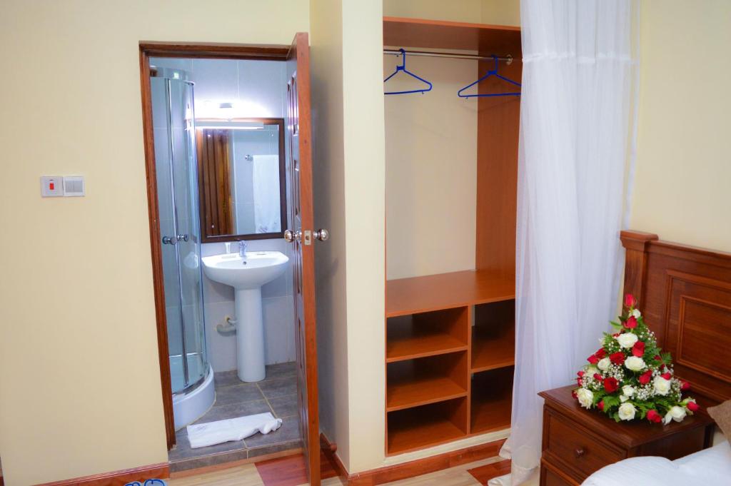 a bathroom with a shower and a toilet and a sink at Red Ruby Hotel in Nairobi