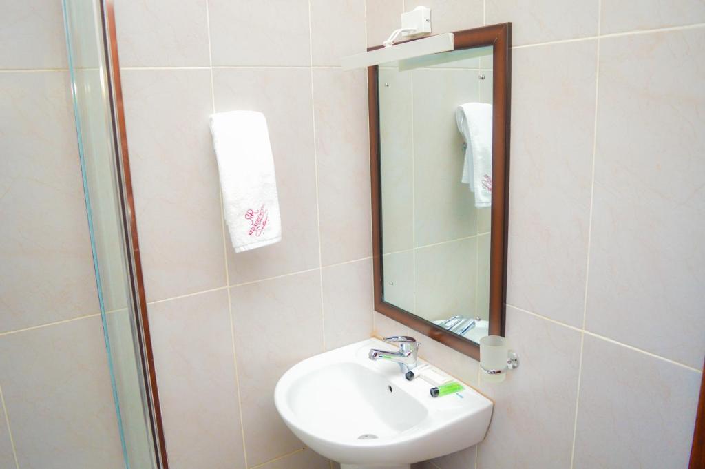 a bathroom with a sink and a mirror at Red Ruby Hotel in Nairobi