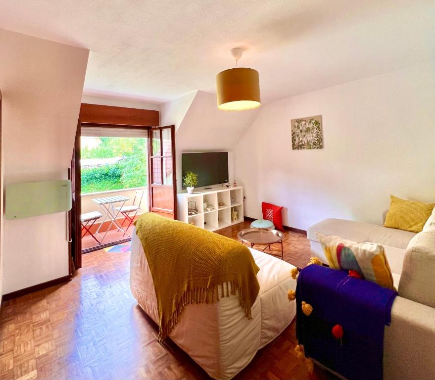 a living room with a bed and a couch at Apartamento Magalsena in San Esteban de Pravia