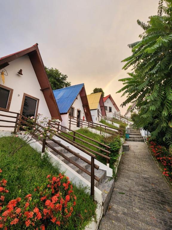 a group of houses with a pathway and flowers at Chalé Monte Betel in Cachoeira Paulista