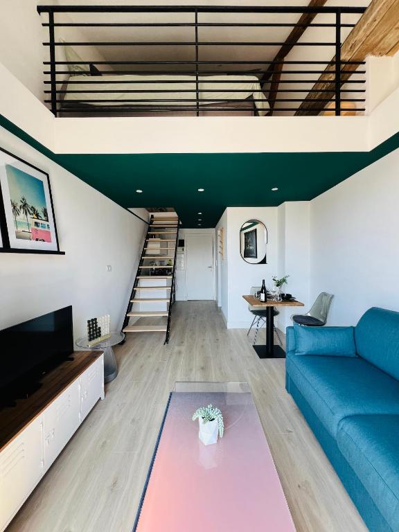 un salon avec un canapé bleu et une table dans l'établissement 307 Gare Saint Roch Montpellier, à Montpellier