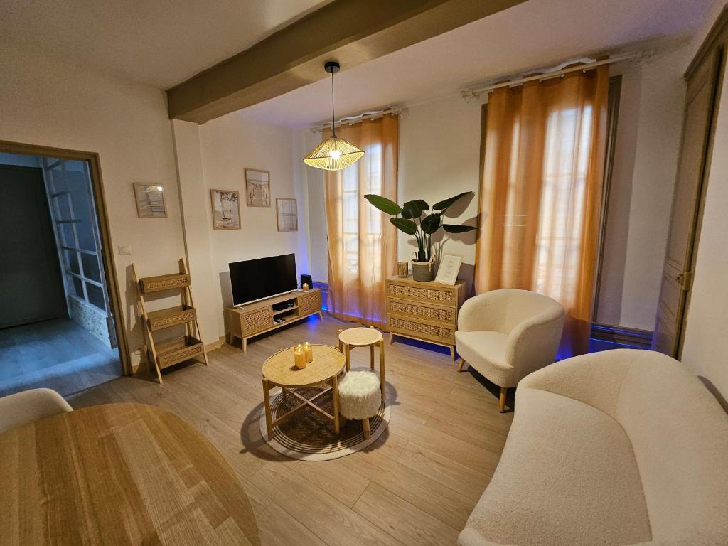 un salon avec une table et une télévision dans l'établissement Appartement cosy hyper centre, à Troyes