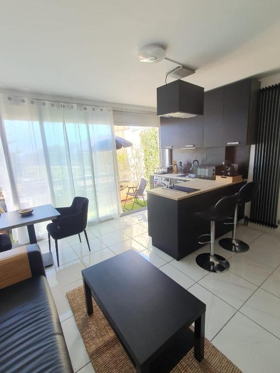 une cuisine et un salon avec une table et des chaises dans l'établissement Studio terrasse vue mer, à Marseille