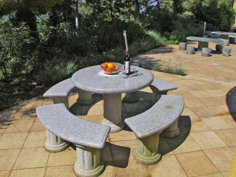 a picnic table with two chairs and a bottle of wine at Holiday Home Yellowhouse in Kaštel