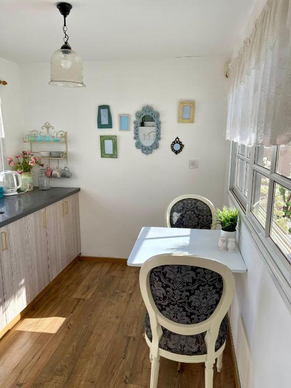 a kitchen with two chairs and a white table at Suits יחידת נופש מתוקה באילת in Eilat