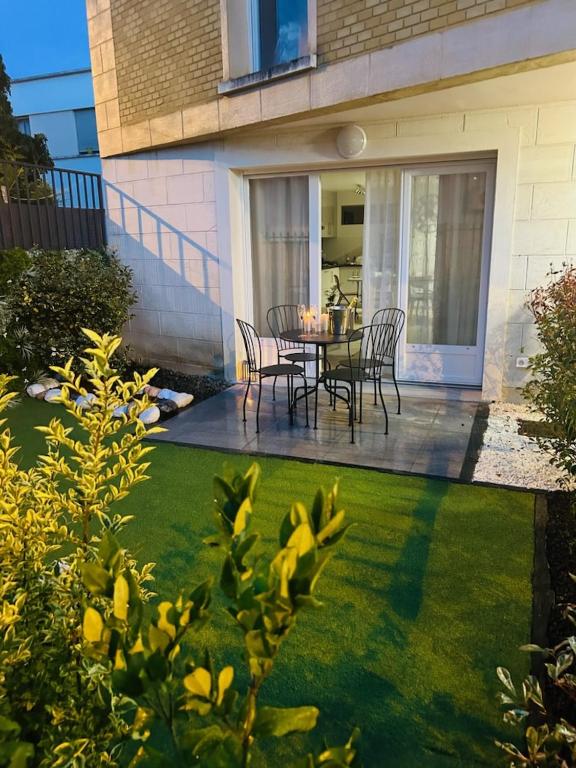 un patio avec une table et des chaises dans une cour dans l'établissement Appartement calme, à Montfermeil