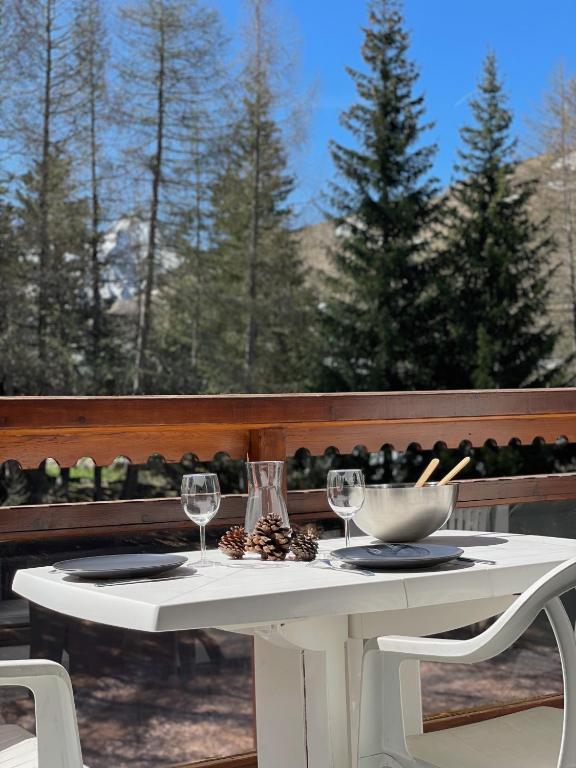 une table blanche avec deux verres et un bol de nourriture dans l'établissement Chez l'Oncle de l'Alpe, à Les Deux Alpes