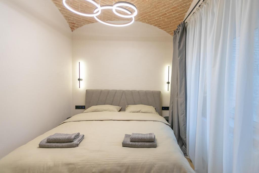 a bedroom with a large bed with two towels on it at Biagio Boutique Studio - in Old Town - Ultra Central in Braşov