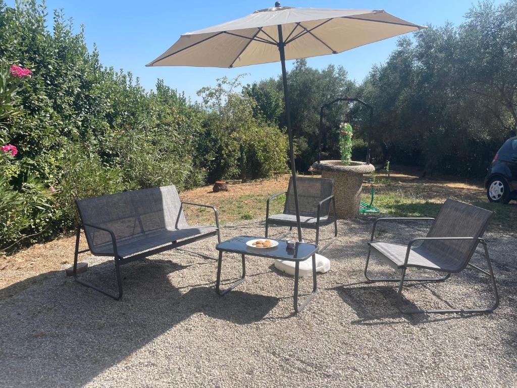 three chairs and a table with an umbrella at Sunshine in Sanfatucchio