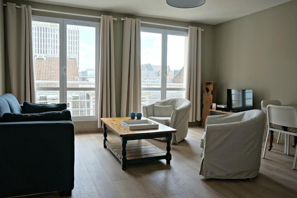 un salon avec un canapé, des chaises et une table dans l'établissement Appartement Vieux Lille avec parking et balcon - Constantine, à Lille