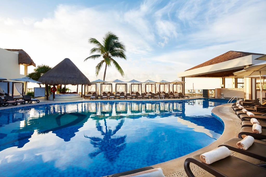 a swimming pool with chairs and a resort at Desire Riviera Maya Resort in Puerto Morelos