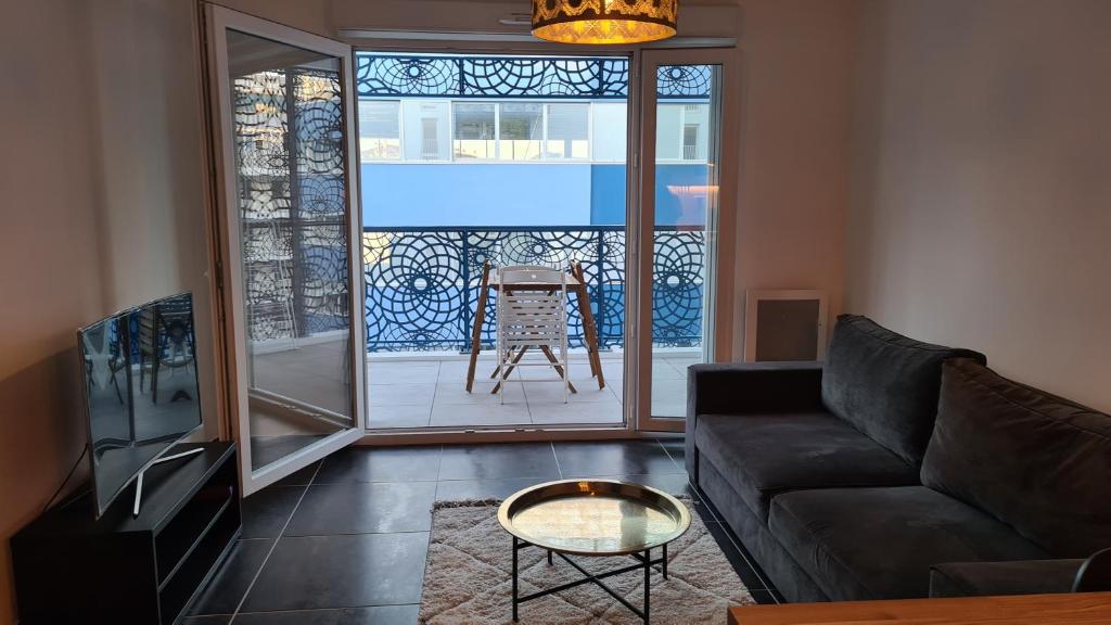- un salon avec un canapé et une fenêtre en verre dans l'établissement Appartement Vélodrome Prado Michelet, à Marseille