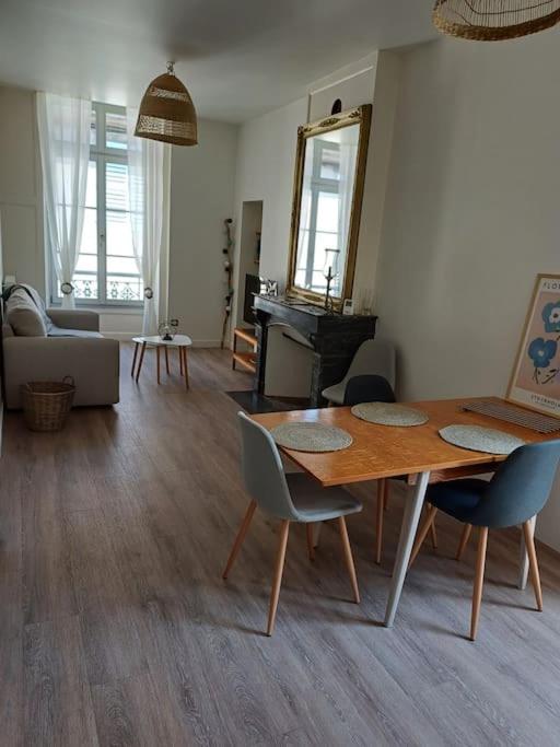 un salon avec une table et des chaises en bois dans l'établissement Appartement T2 50m2 Site remarquable, à Lons-le-Saunier