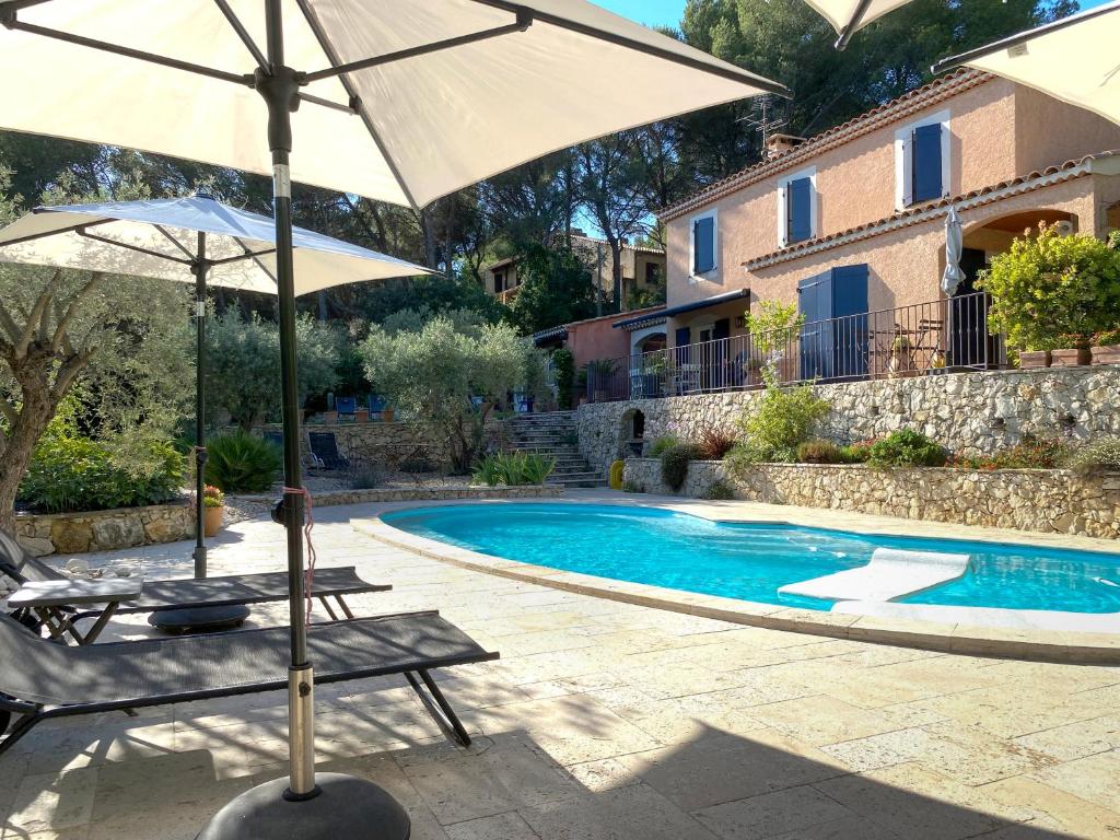 deux chaises et un parasol à côté d'une piscine dans l'établissement la chamade grande chambre B&B indépendante, à Ventabren