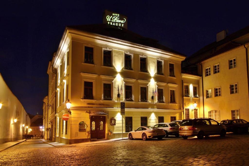 a building with cars parked in front of it at night at U Páva in Prague
