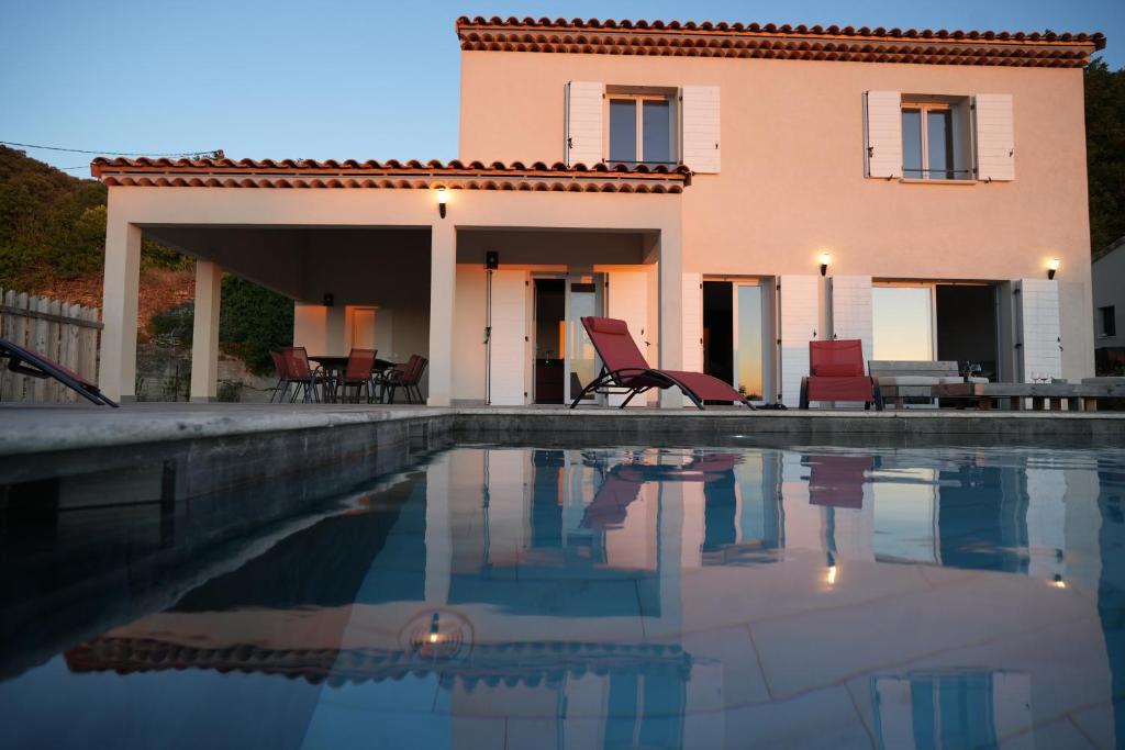 une maison avec une piscine devant dans l'établissement La Farnientaise - 10 pers, boulodrome, clim, piscine, billard, à Bonnieux